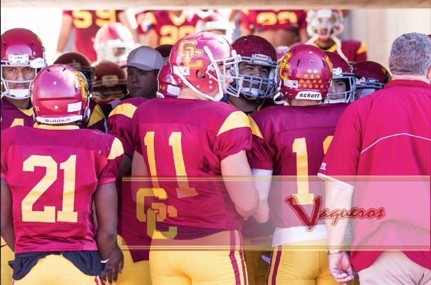GCC Football team huddled together reviewing their next play.